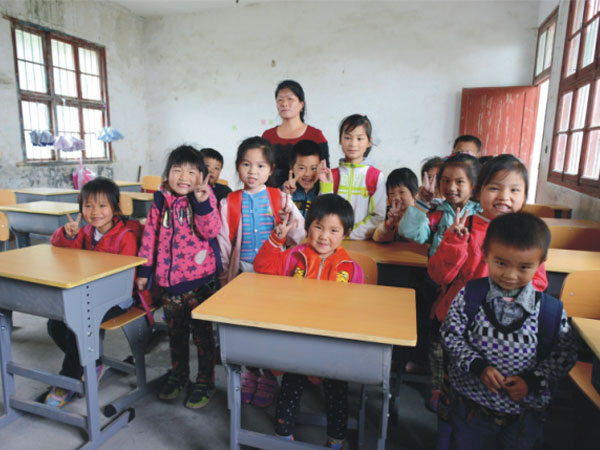 公司為一山村小學(xué)捐贈一批課桌椅，孩子們高興地和老師一起合影